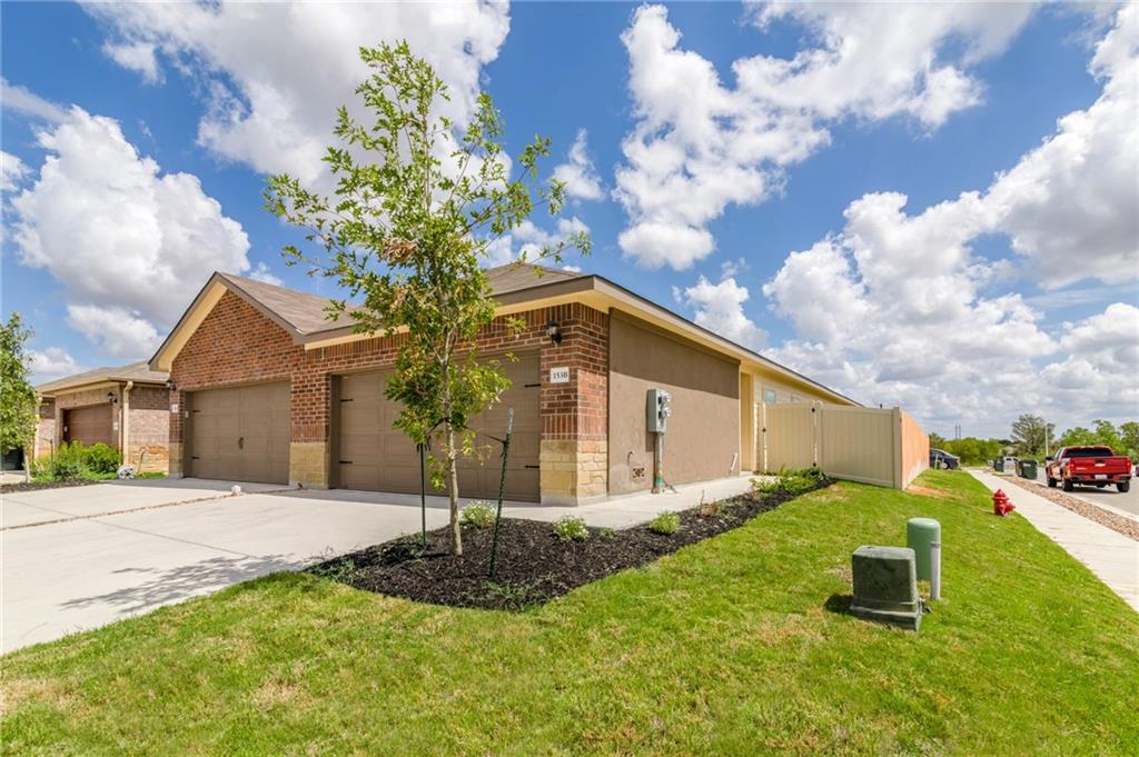 153 Samuel Drive, Unit B Buda, TX 78610 - Photo 21 of 28 a front view of a house with garden