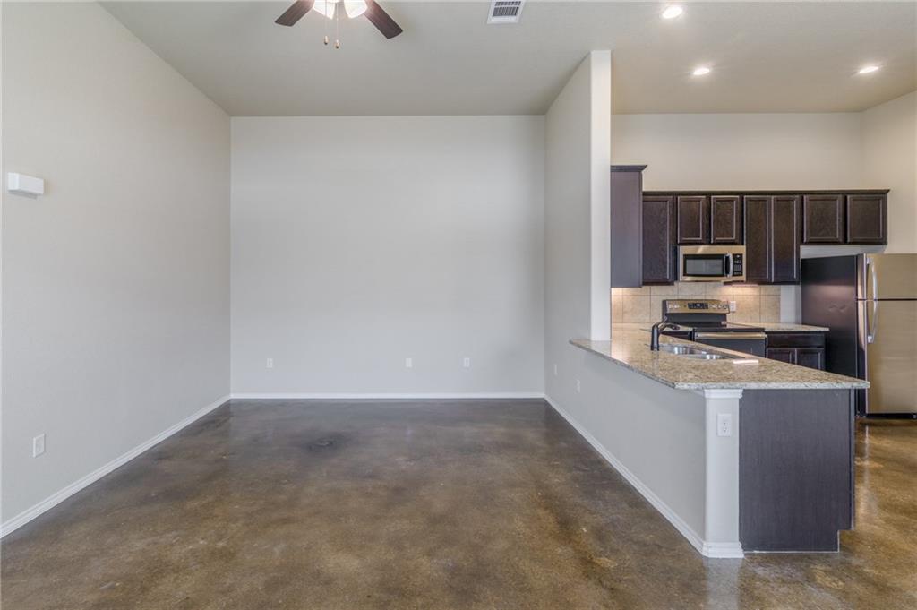153 Samuel Drive, Unit B Buda, TX 78610 - Photo 10 of 28 a kitchen with stainless steel appliances a refrigerator and a stove top oven