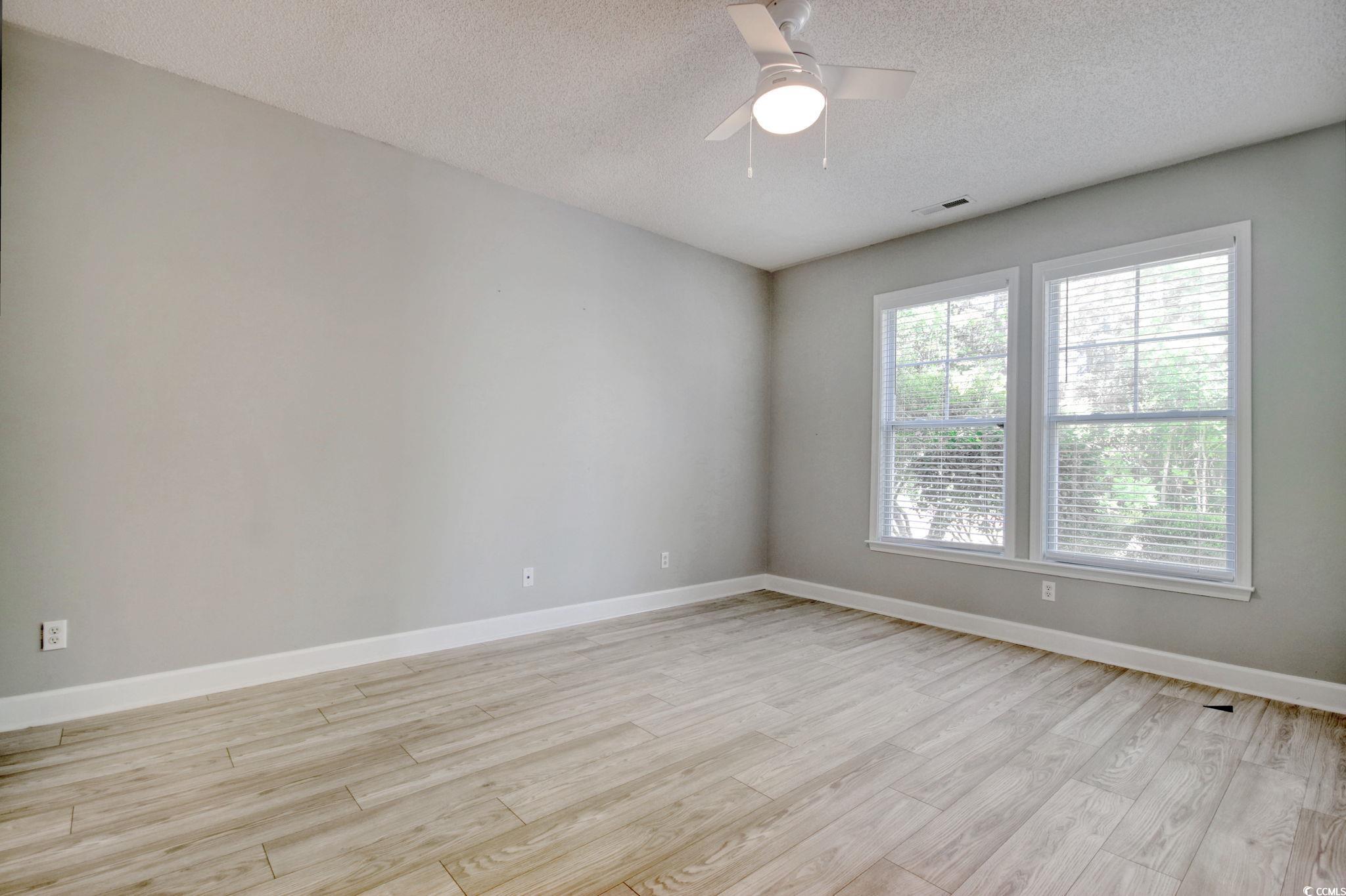 112 Coldstream Cove Loop, Unit 306 Murrells Inlet, SC 29576 - Photo 15 of 32 Primary bedroom featuring LVP flooring, ceiling fan, walk-in closet and ensuite bathroom.