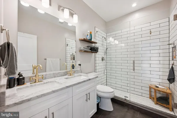 a bathroom with a granite countertop toilet sink and mirror