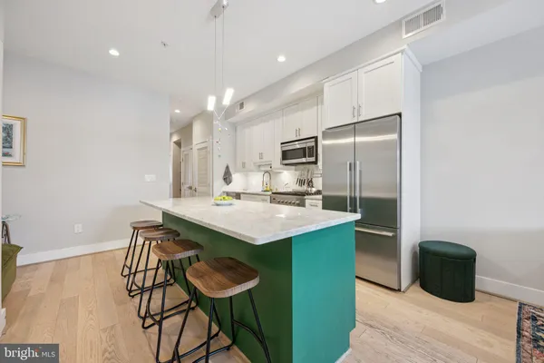 a kitchen with kitchen island a sink stove and refrigerator