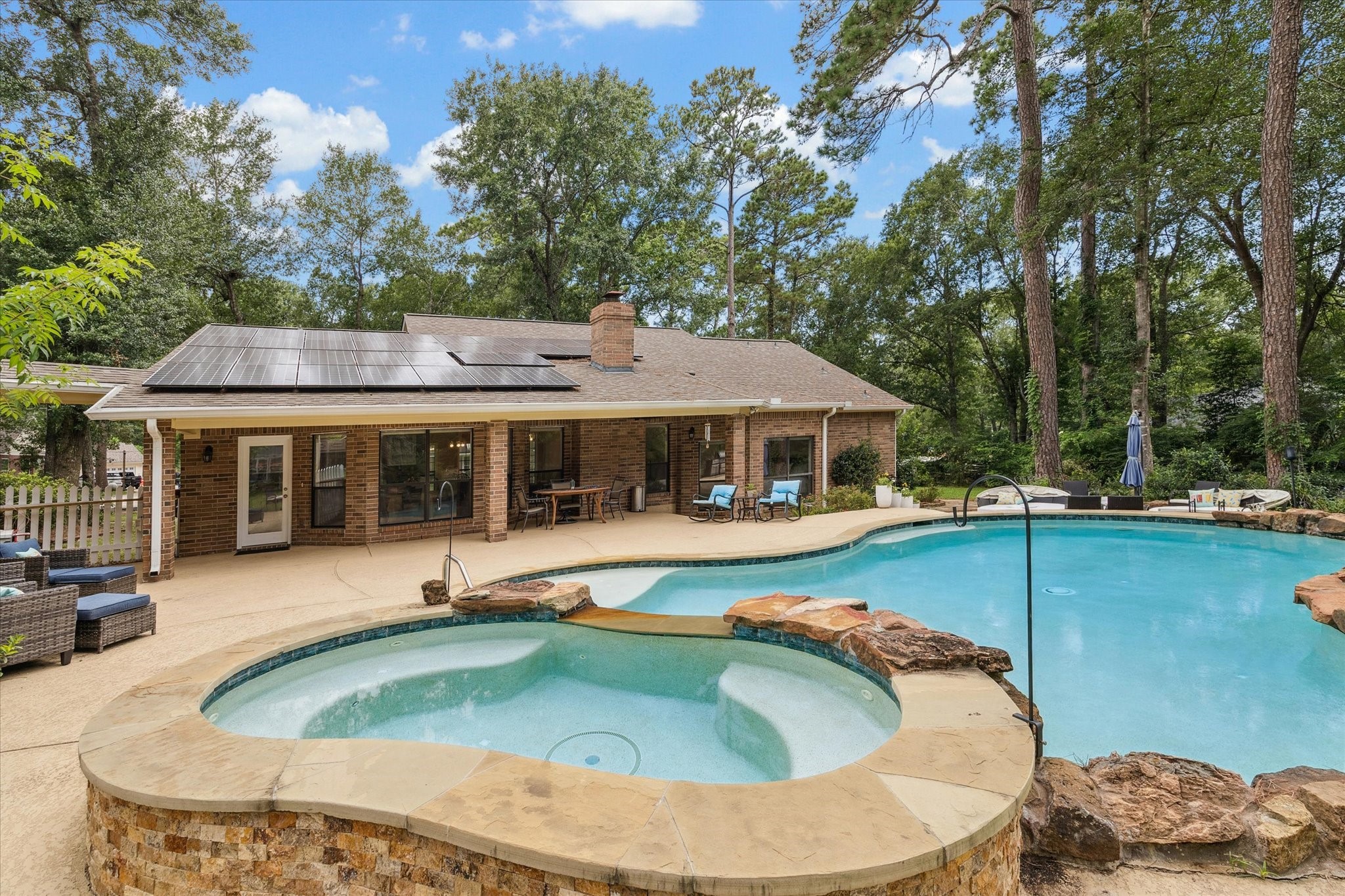 23818 Pin Oak Drive Spring, TX 77389 - Photo 2 of 31 The spa overflows into the pool beside a rock waterfall feature, while the covered patio provides the perfect place to unwind or entertain.