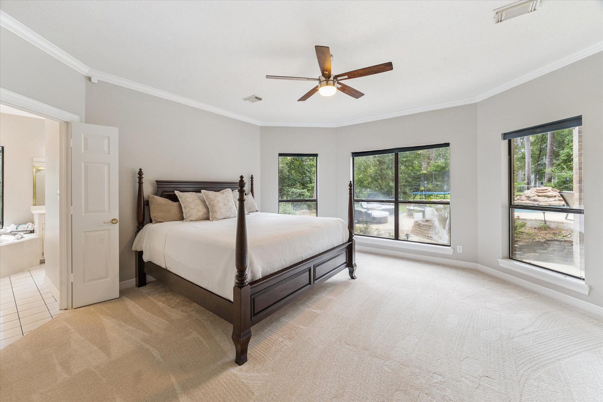 23818 Pin Oak Drive Spring, TX 77389 - Photo 21 of 31 Serene primary retreat with oversized windows offering views of the backyard oasis and pool—your private haven to unwind.