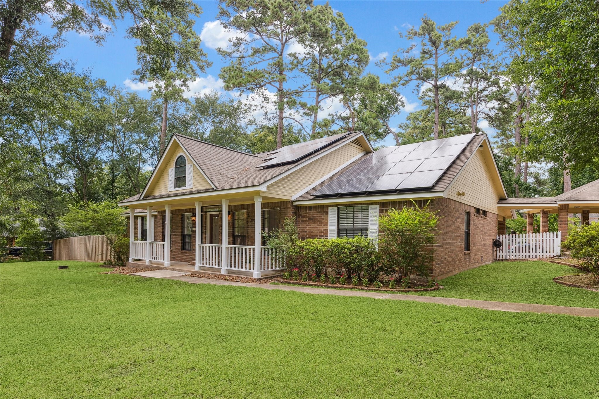 23818 Pin Oak Drive Spring, TX 77389 - Photo 8 of 31 A side view of the home reveals solar panels and beautifully maintained landscaping, combining sustainability with Southern charm.