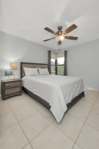a bedroom with a bed and a ceiling fan