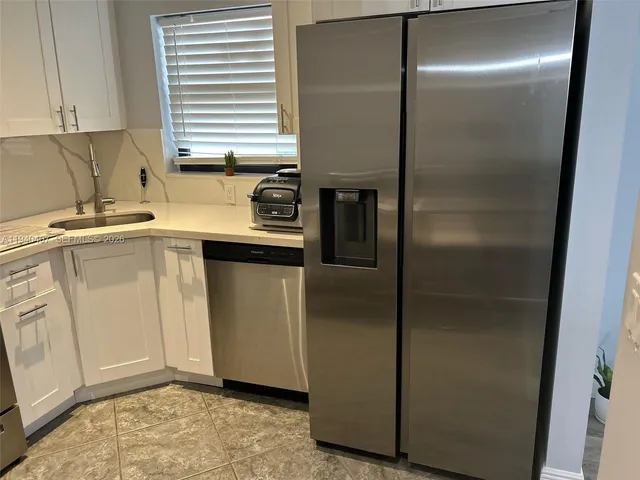 a kitchen with a refrigerator and a sink