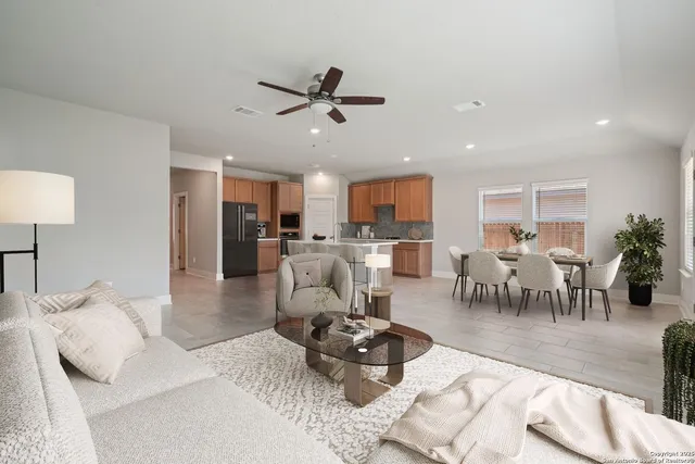 a living room with furniture and a view of kitchen