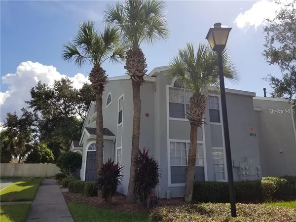 a view of a house with a yard and potted plants