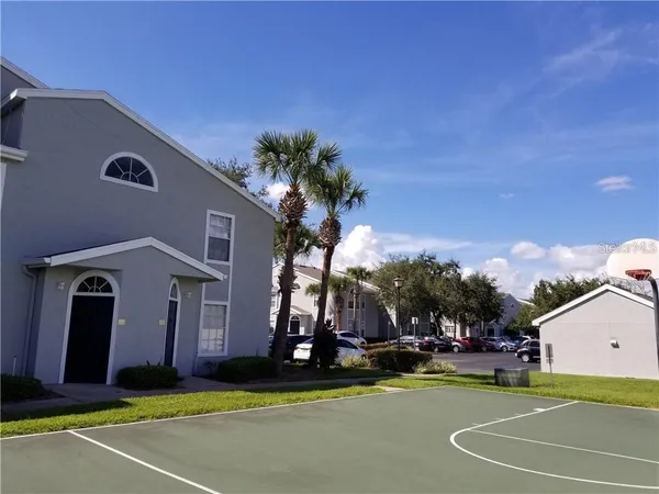 a view of a building with a swimming pool and a chairs and tables in patio