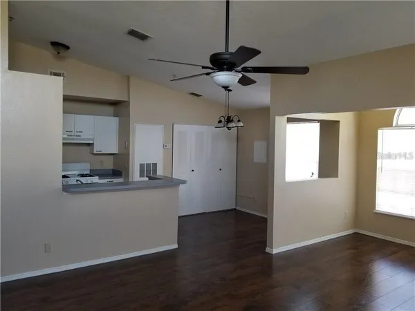 a kitchen with a refrigerator a sink and wooden floor