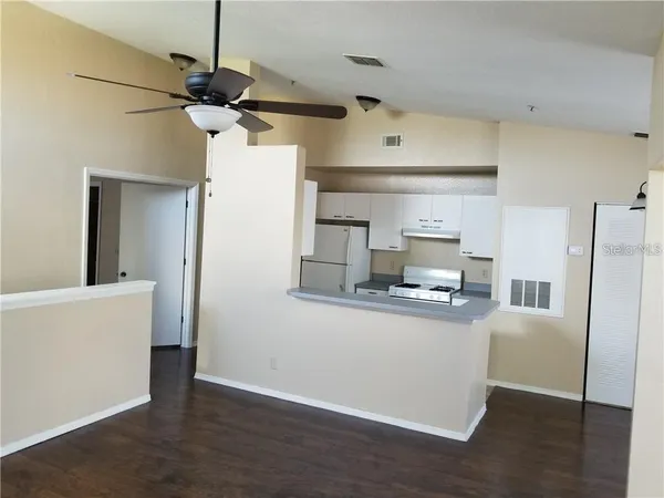 a kitchen with stainless steel appliances a stove a refrigerator and white cabinets
