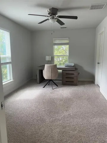a spacious bedroom with a bed and a ceiling fan