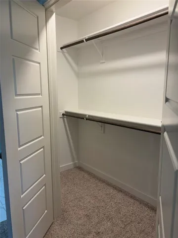 a view of a hallway with closet and mirror