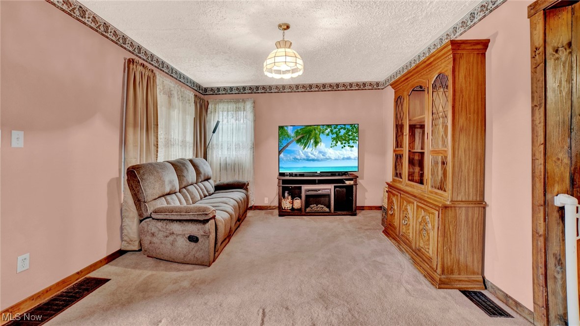 337 Pomerene Road Mansfield, OH 44906 - Photo 9 of 32 Living area featuring a textured ceiling and light colored carpet