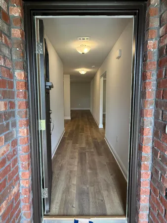 a view of a hallway with a livingroom and a bathroom with sink