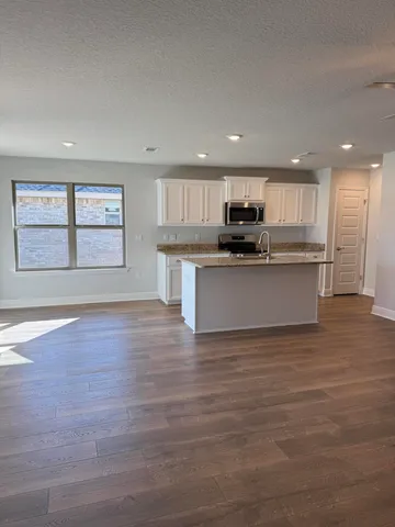 a view of kitchen with sink microwave and refrigerator