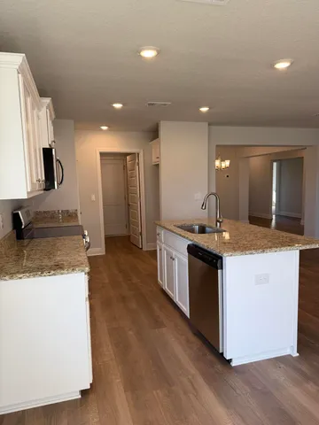 a large kitchen with stainless steel appliances granite countertop a sink and a stove