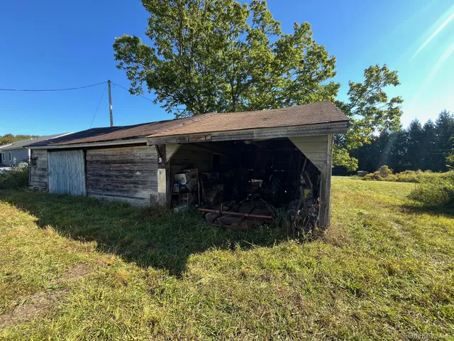 a view of backyard with wooden fence and a large tree