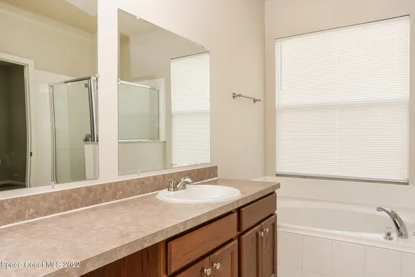 a bathroom with a granite countertop sink and a bathtub