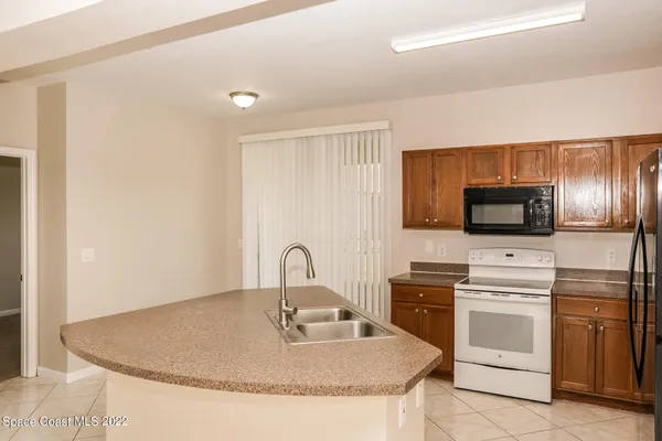 a view of an empty room with chandelier fan