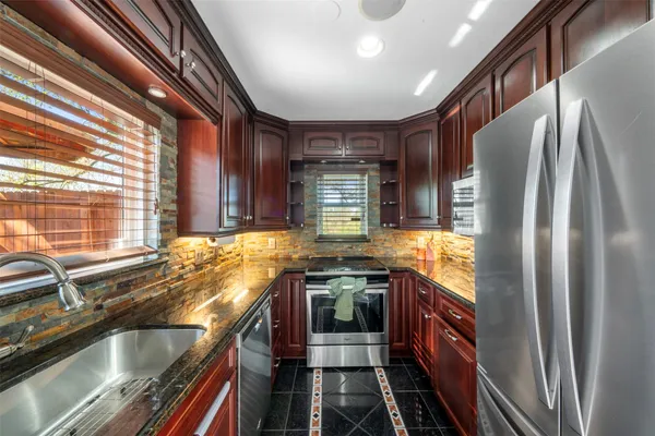 a bathroom with a granite countertop sink a toilet a mirror and shower