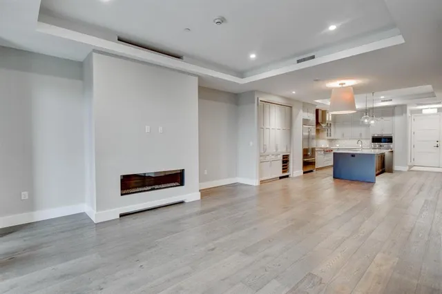 a view of kitchen with stainless steel appliances wooden floor and windows