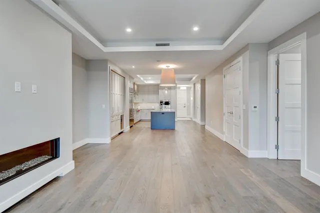 a view of a big room with wooden floor and windows
