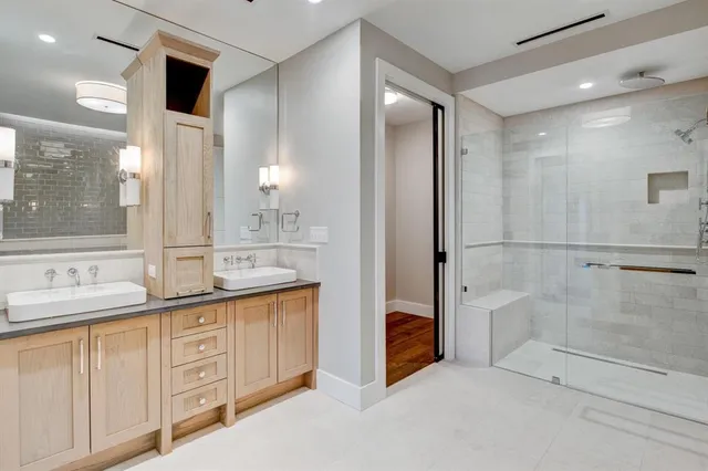 a bathroom with a double vanity sink a mirror and a shower