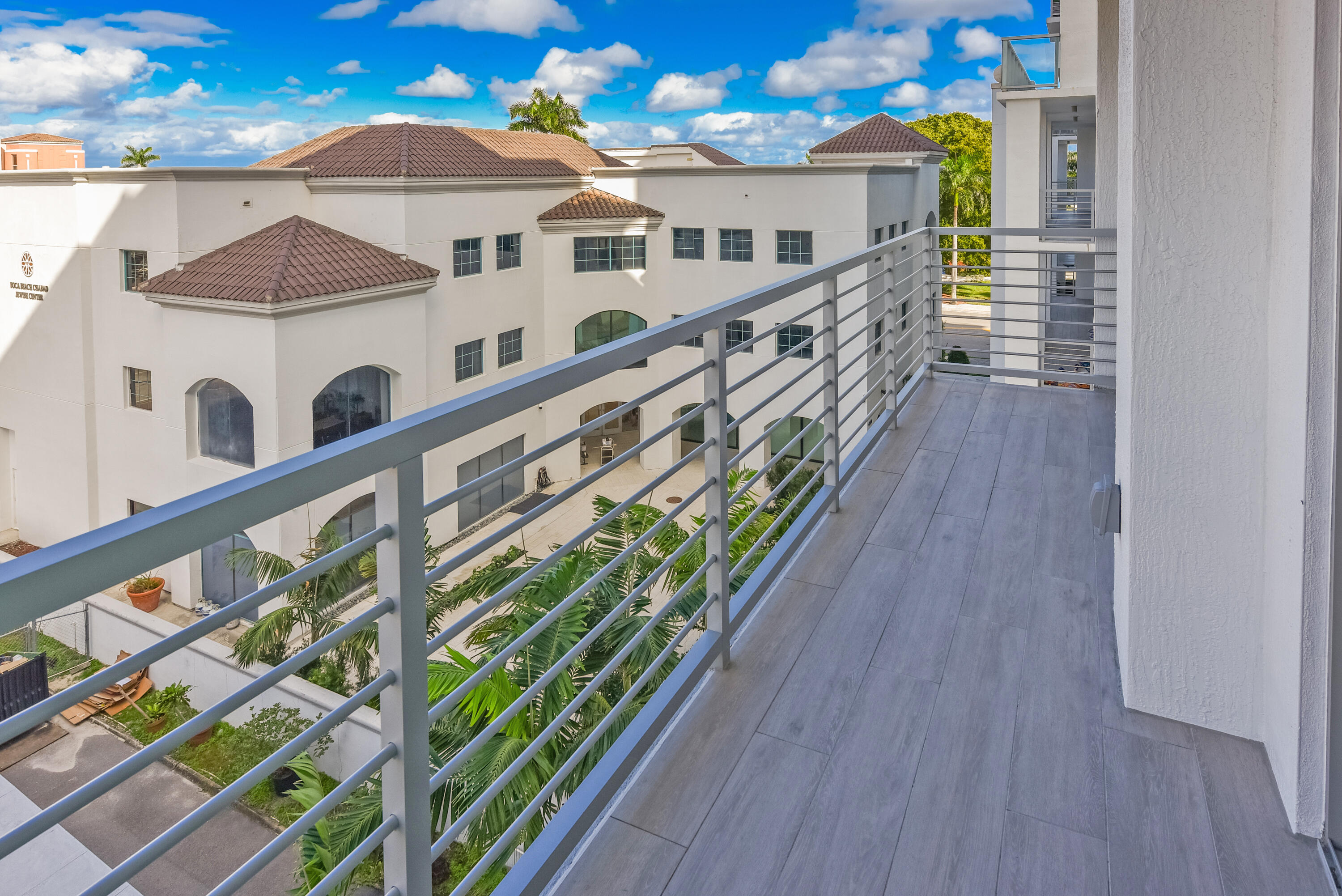 485 East Royal Palm Road, Unit 403 Boca Raton, FL 33432 - Photo 23 of 74 a view of balcony with two large buildings and wooden floor