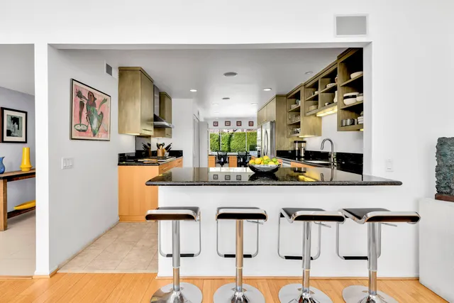 a kitchen with stainless steel appliances kitchen island granite countertop a refrigerator and cabinets