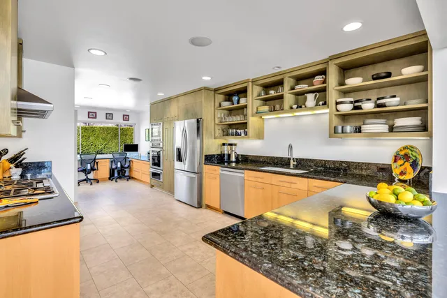 a kitchen with stainless steel appliances granite countertop a sink stove and refrigerator