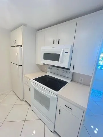a view wooden floor and a refrigerator in a kitchen