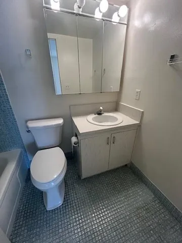 a bathroom with a toilet sink and mirror