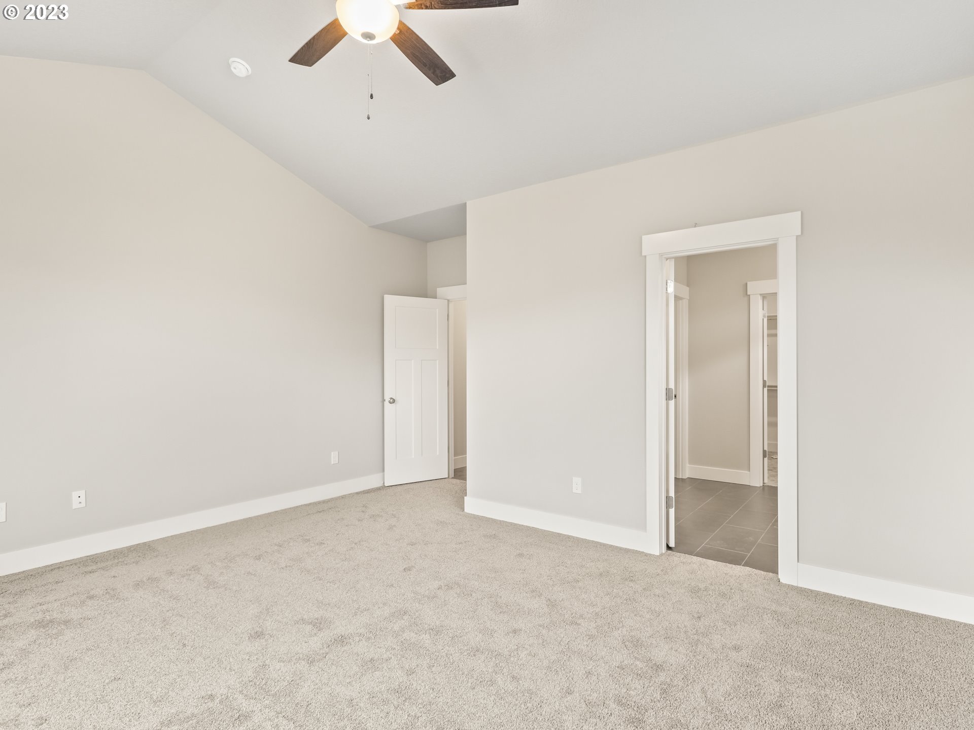 652 Northeast Pinebreak Drive Estacada, OR 97023 - Photo 29 of 40 an empty room with a ceiling fan and carpet