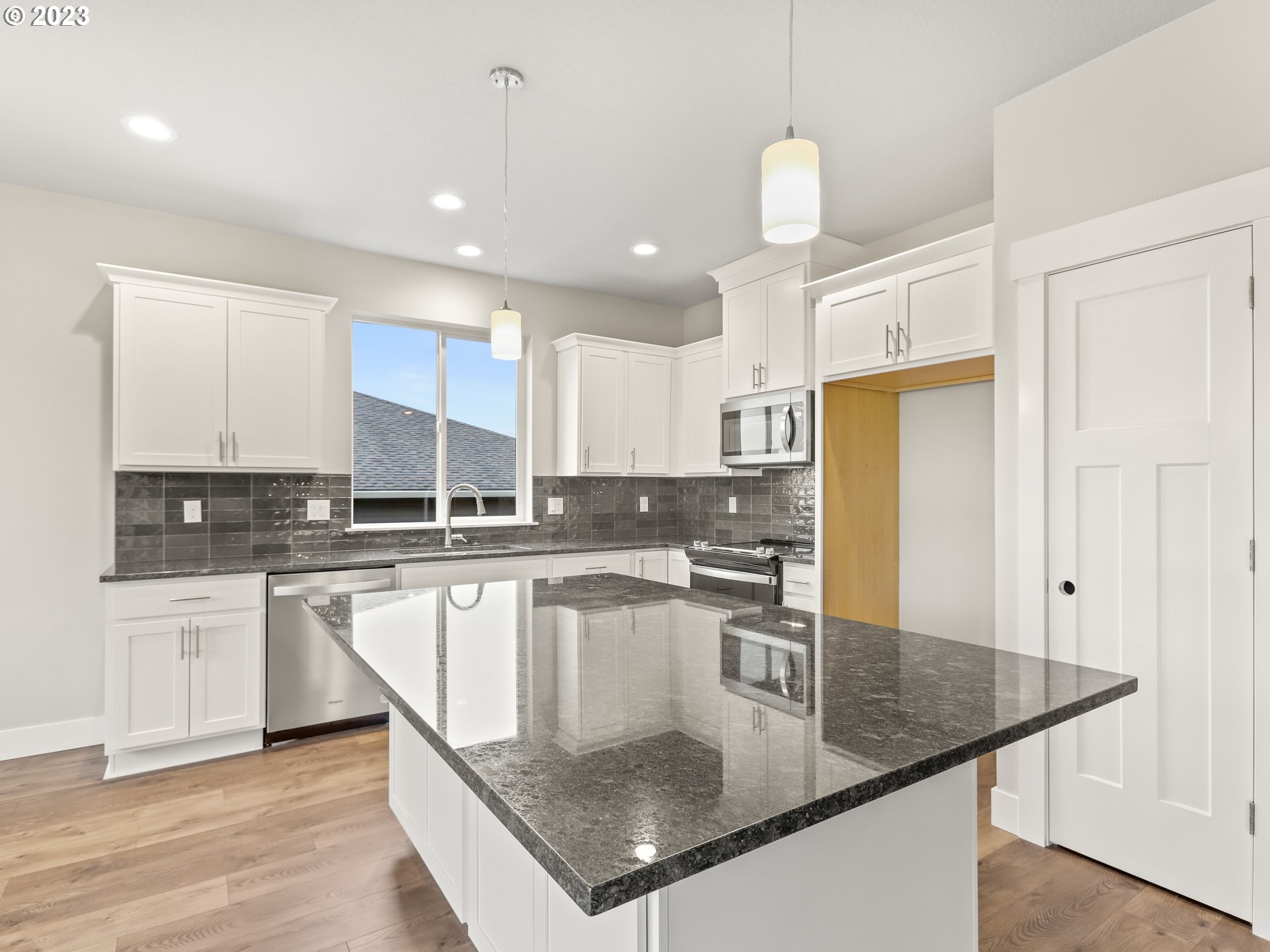 652 Northeast Pinebreak Drive Estacada, OR 97023 - Photo 10 of 40 a kitchen with stainless steel appliances granite countertop a sink window and cabinets