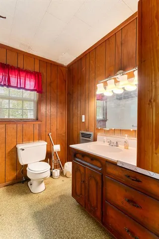 a bathroom with a granite countertop sink and a large mirror next to a window