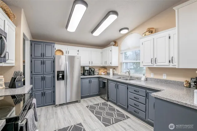 a kitchen with refrigerator cabinets and a sink