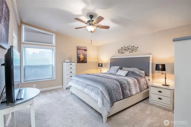 a spacious bedroom with a bed and a chandelier