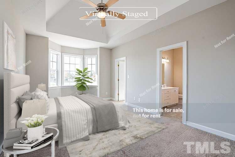 8909 Sauls Road Raleigh, NC 27603 - Photo 3 of 23 a bedroom with a bed and a chandelier