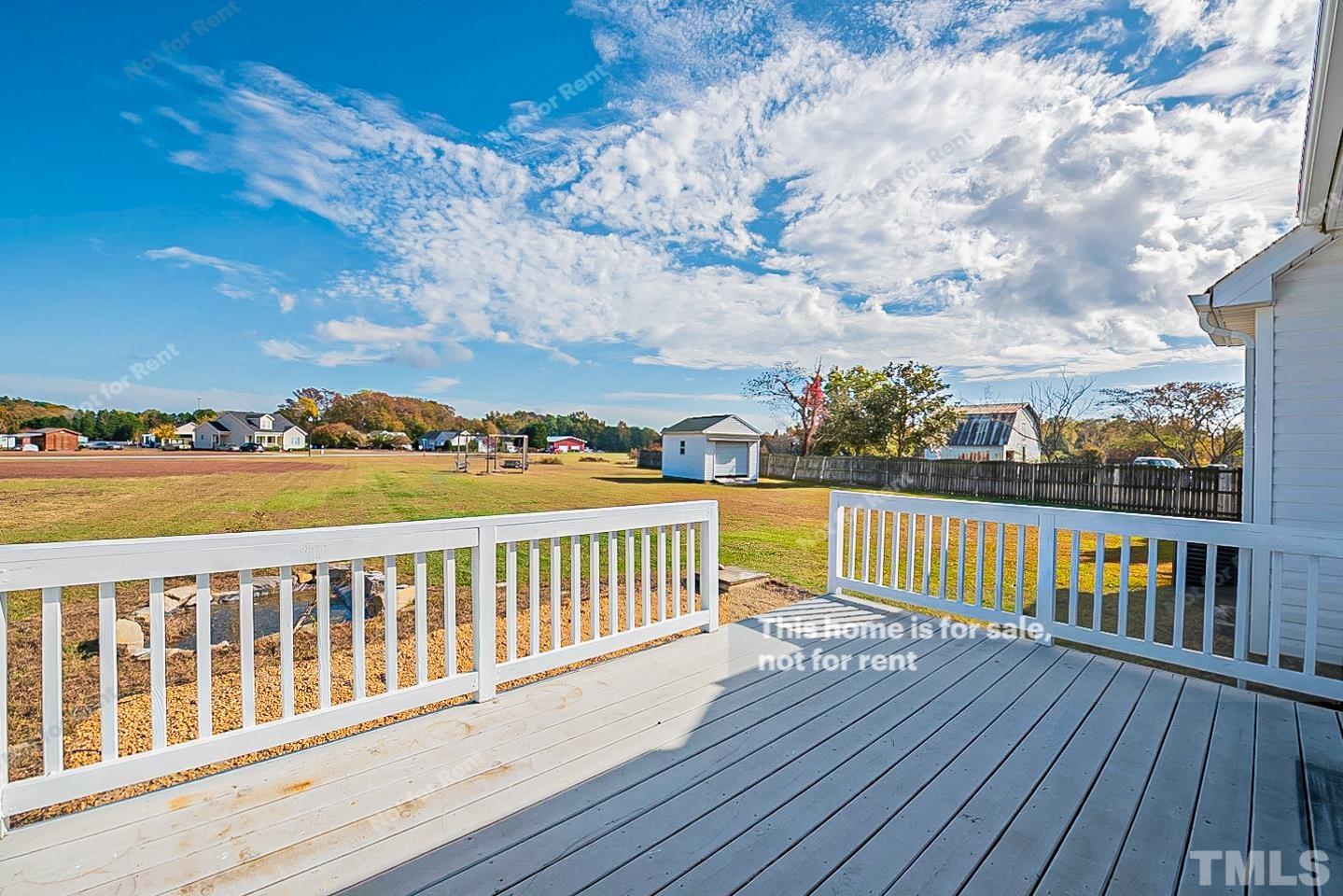 8909 Sauls Road Raleigh, NC 27603 - Photo 23 of 23 a view of roof deck with two chairs and wooden floor