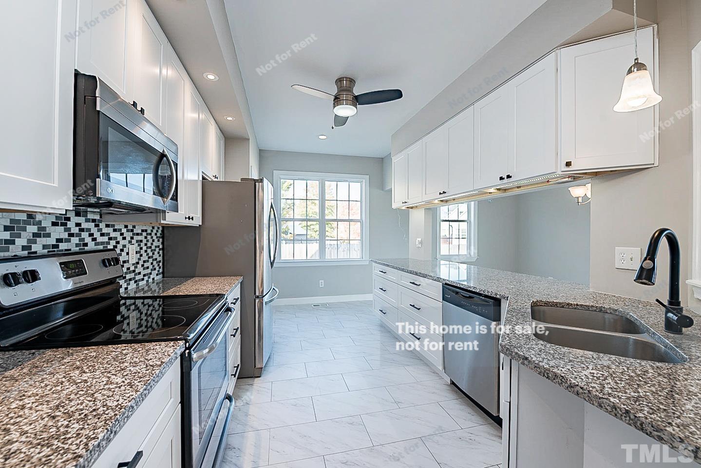 8909 Sauls Road Raleigh, NC 27603 - Photo 4 of 23 a kitchen with a sink stove top oven and refrigerator