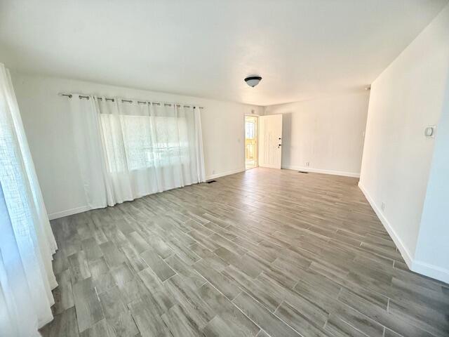 51555 Monroe Street Indio, CA 92201 - Photo 13 of 29 an empty room with wooden floor and windows