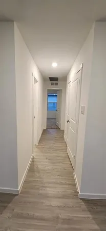 a view of a hallway with wooden floor
