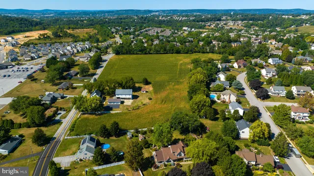an aerial view of residential houses with outdoor space and trees