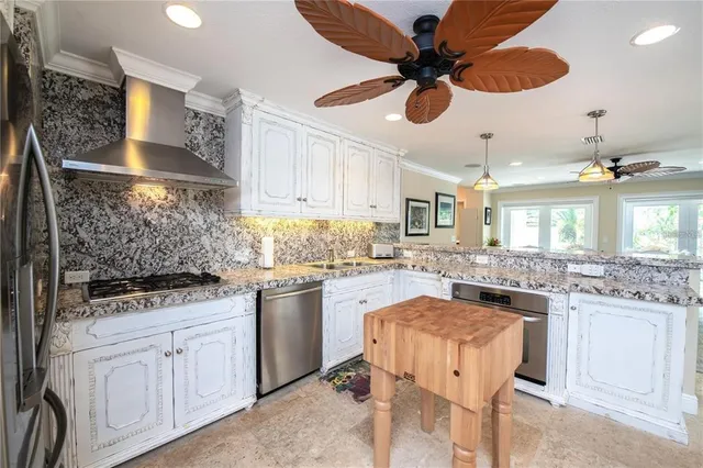 a kitchen with white cabinets and chandelier