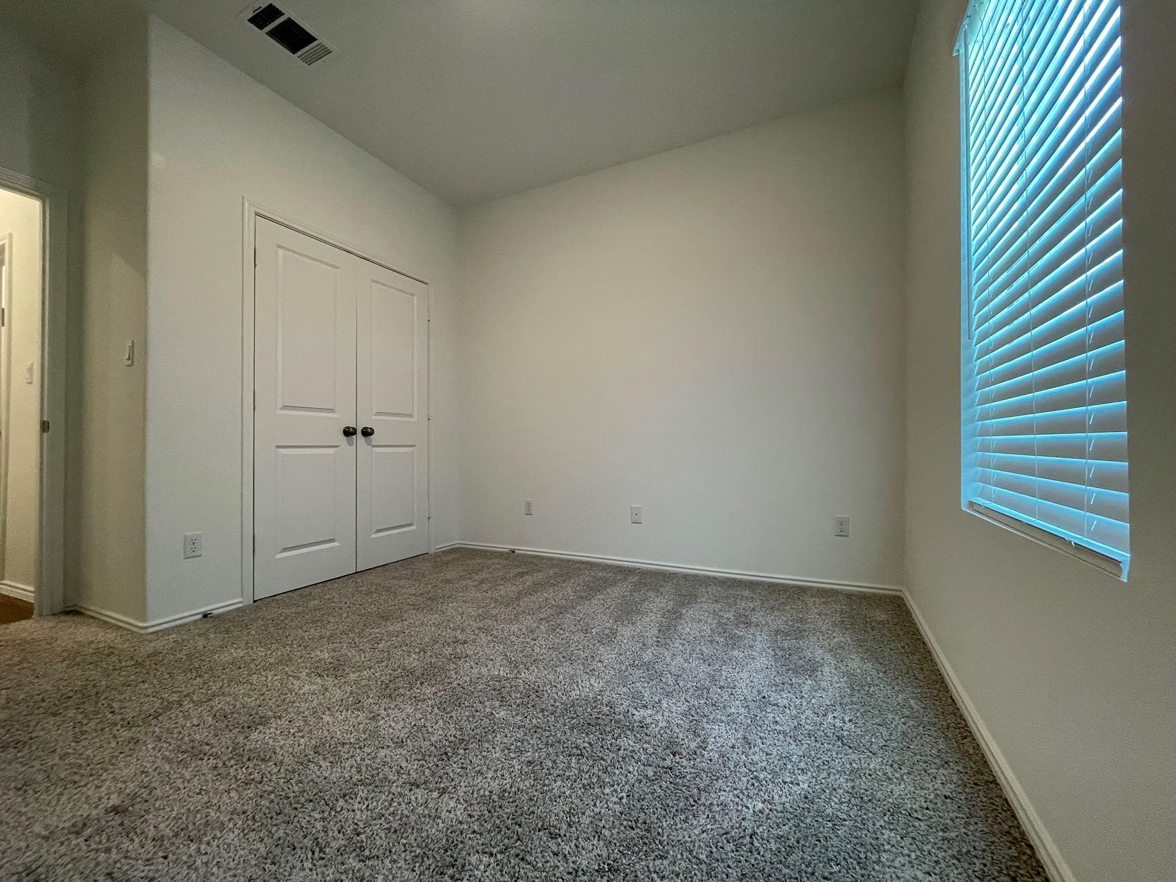 1625 Woolsey Way Leander, TX 78641 - Photo 7 of 17 The room features gray carpet flooring, white walls, and a window with blinds