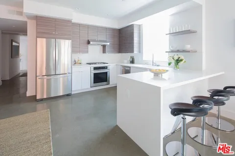 a kitchen with a sink stainless steel appliances and white cabinets
