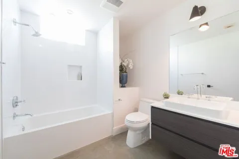 a bathroom with a bathtub shower sink and toilet