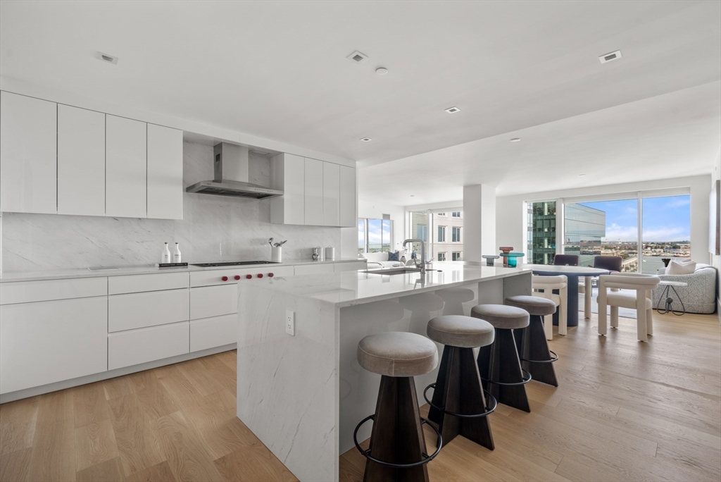 150 Seaport Boulevard, Unit 15CD Boston, MA 02210 - Photo 12 of 39 a kitchen with white cabinets and chairs