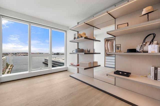 a large white kitchen with a large window and stainless steel appliances